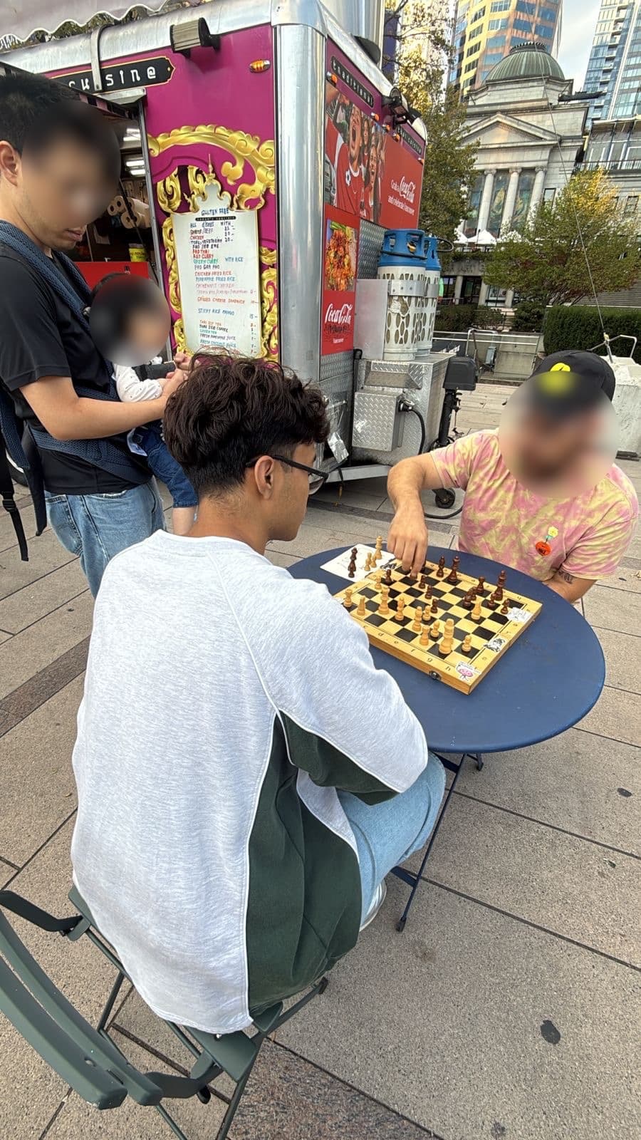 Playing chess against a stranger at a street table on Robson.